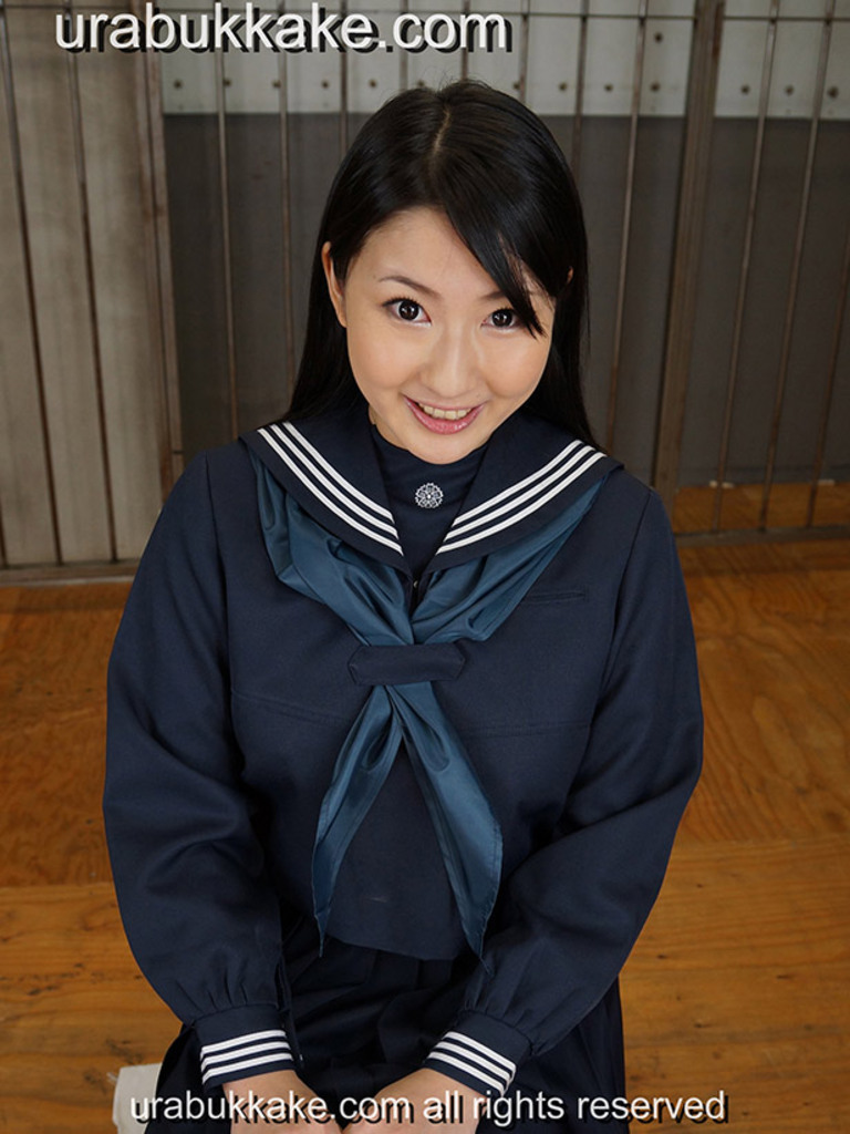 Kogal seated in uniform hands on her laps